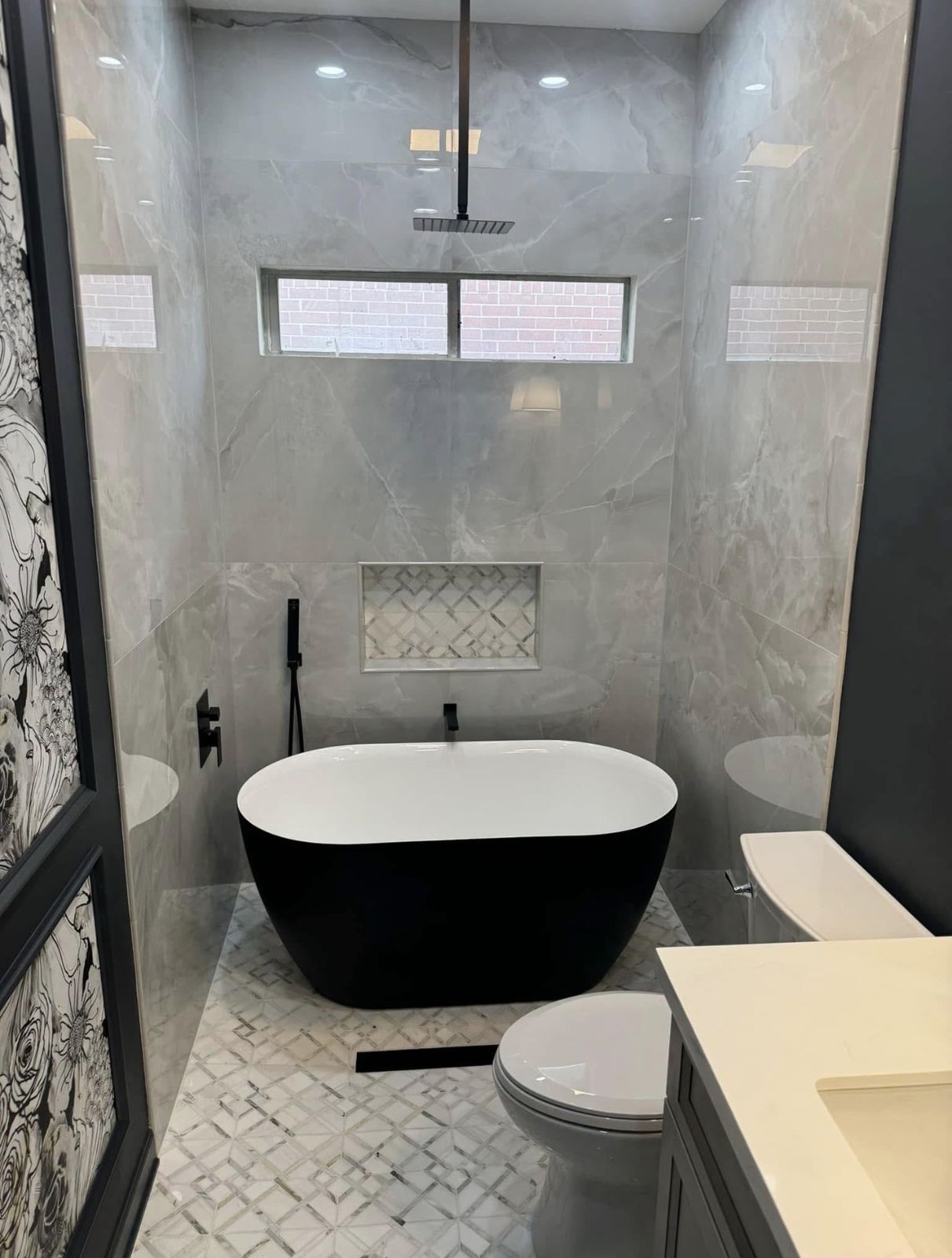 Freestanding black tub with marble-look tile