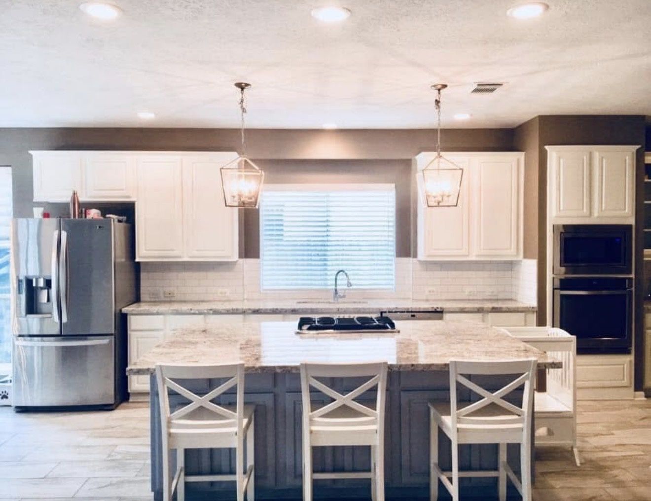 Kitchen with white cabinets, large island and pendant lights